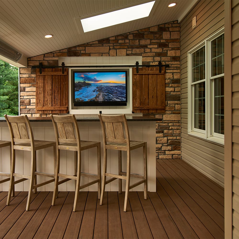 This feature wall creates privacy from the neighbor and doubles as the entertainment hub of the deck! The barnwood, stone veneer and metal accents complement each other in a timeless harmony.