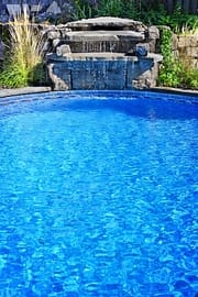 outdoor inground residential private swimming pool with waterfall
