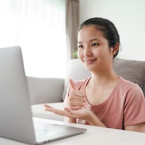 Woman using ASL in front of laptop