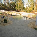 Pool surrounded by stamped concrete patio and landscaping