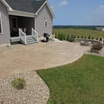 Decorative stamped concrete patio with fire pit and sitting wall