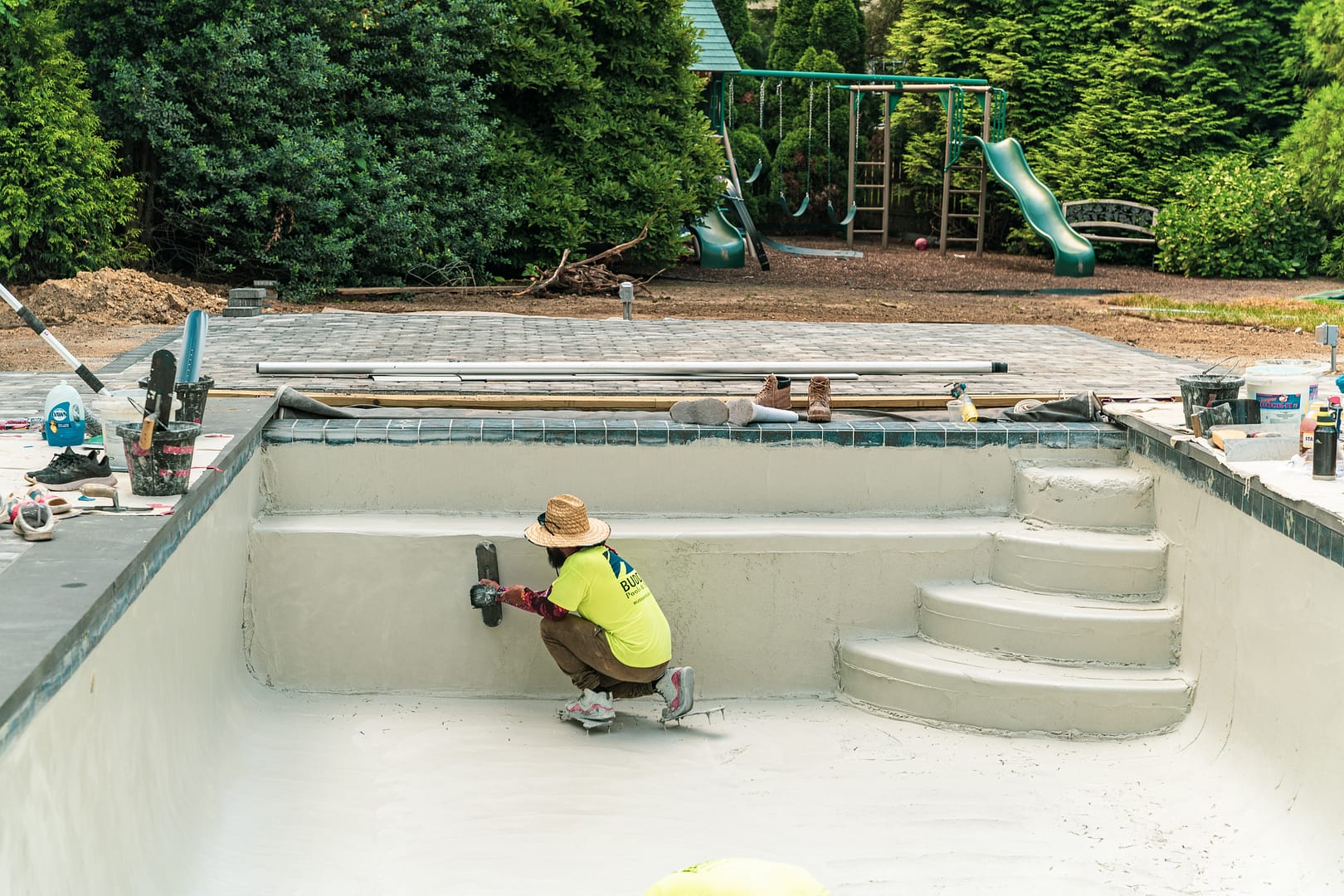 A Budd craftsman hand-applies new plaster to rebuild the pool’s interior.