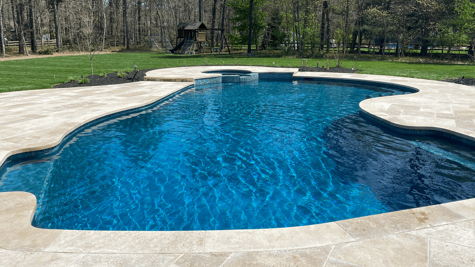 A recently renovated concrete and plaster pool in South Jersey: The renovation by Budd Pools & Spas includes a repaired and refinished pool and spa, new glass tile and new travertine coping and decking.