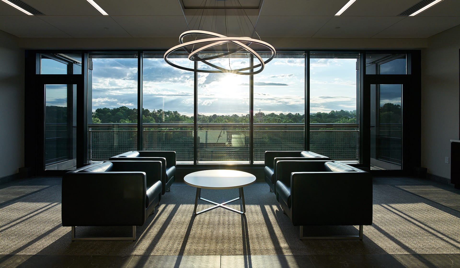 Tenant reception with black chairs glowing in sunrise light at 615 Waterfront