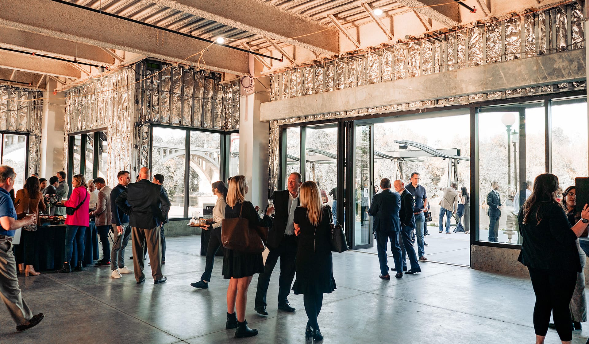Guests mingling indoors at the evening grand opening of 615 Waterfront in Allentown