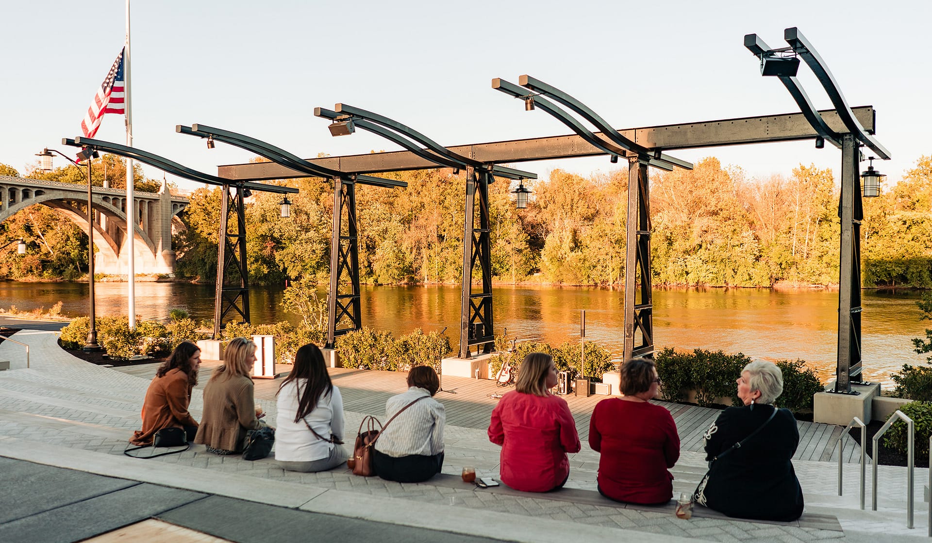 Guests gathered under a string-lit steel pergola at an evening event at The Waterfront