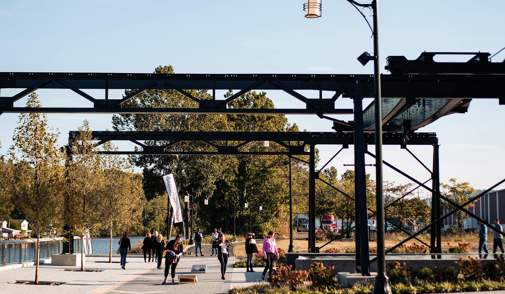 String-lit walkway beneath a steel trestle during an evening event at The Waterfront