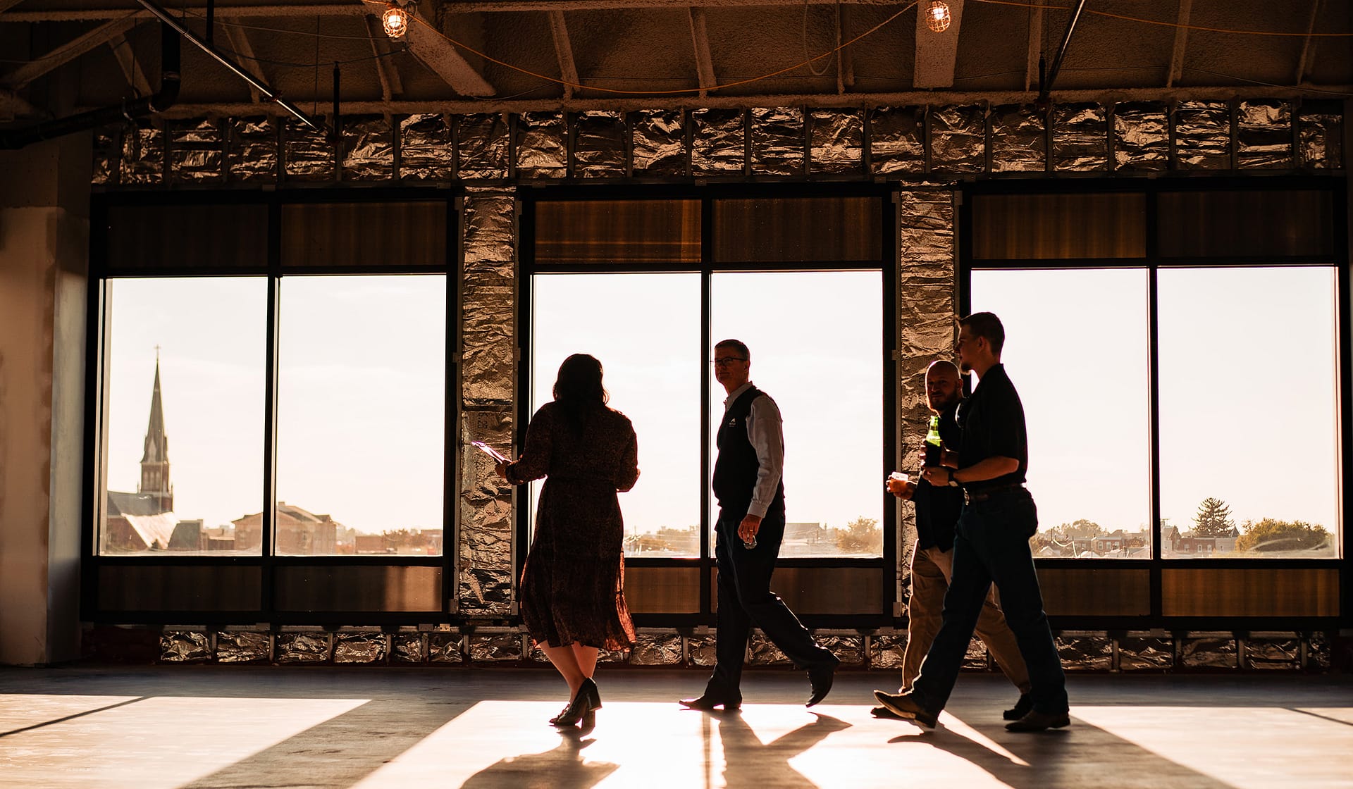 Silhouetted guests inside a glass lobby with bridge views at 615 Waterfront