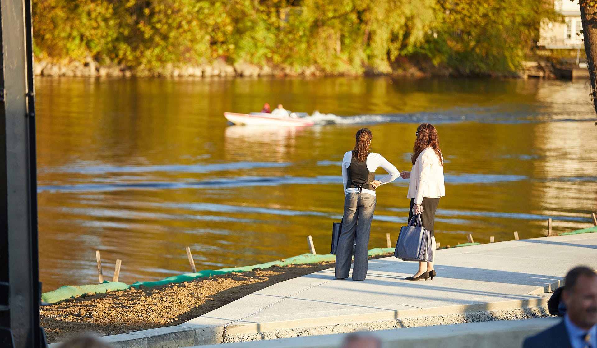 Guests along the Lehigh River at sunset during a broker open house at The Waterfront