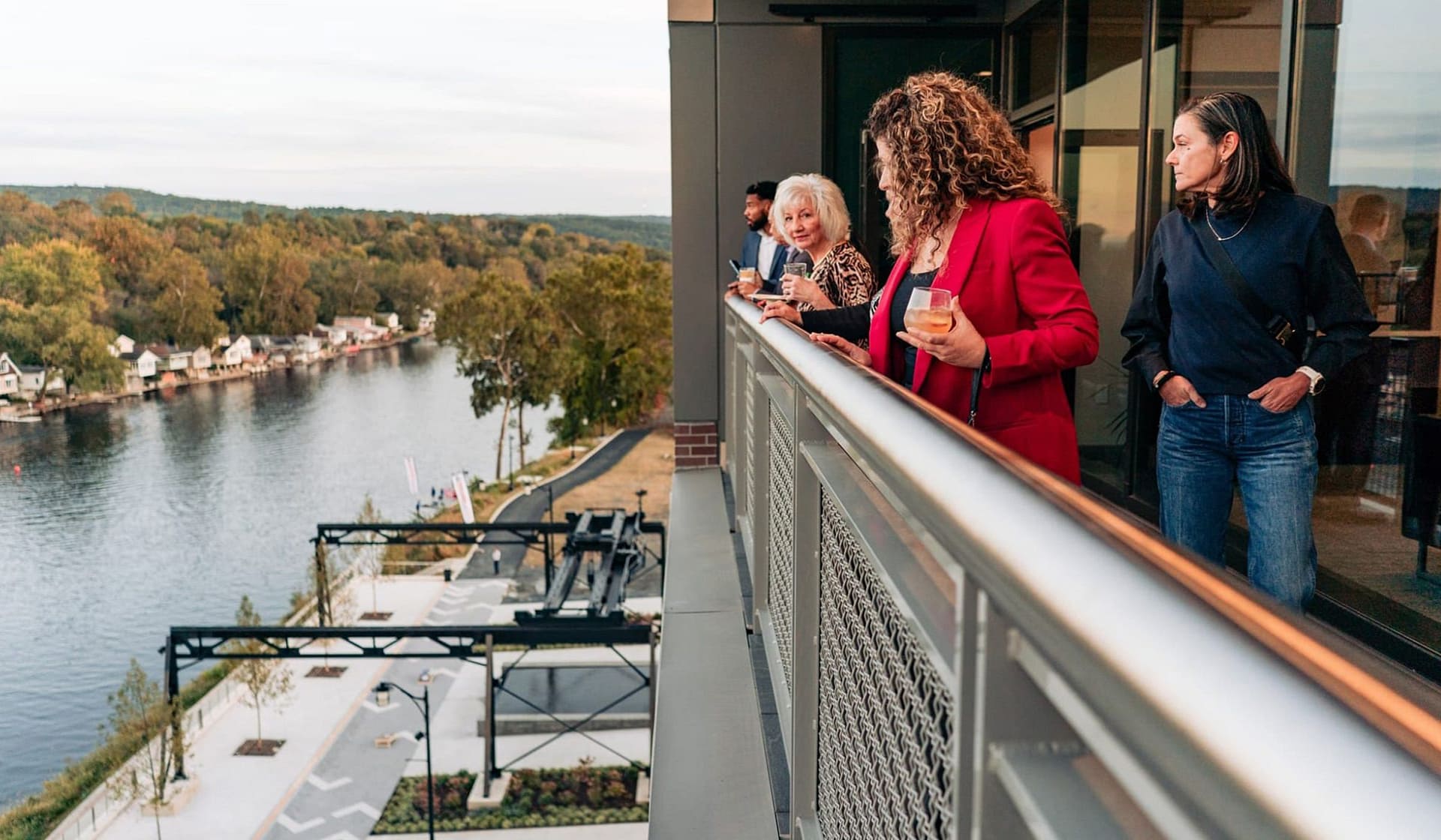 Guests taking in Lehigh River views from a terrace during an evening event at The Waterfront