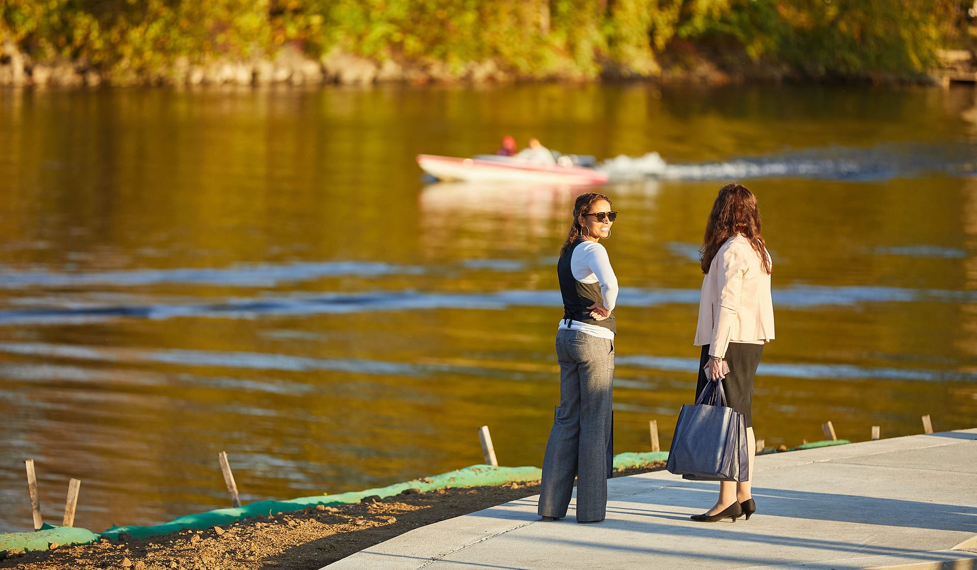 Two guests by the Lehigh River at golden hour during a broker event at The Waterfront
