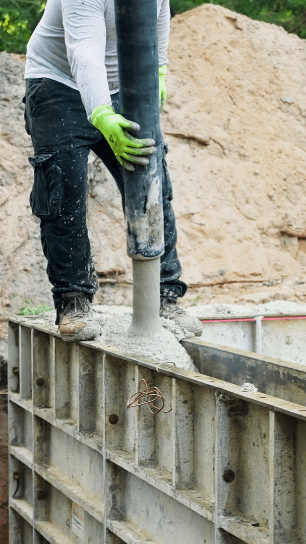Concrete is poured to form the base structure of a custom vinyl pool.