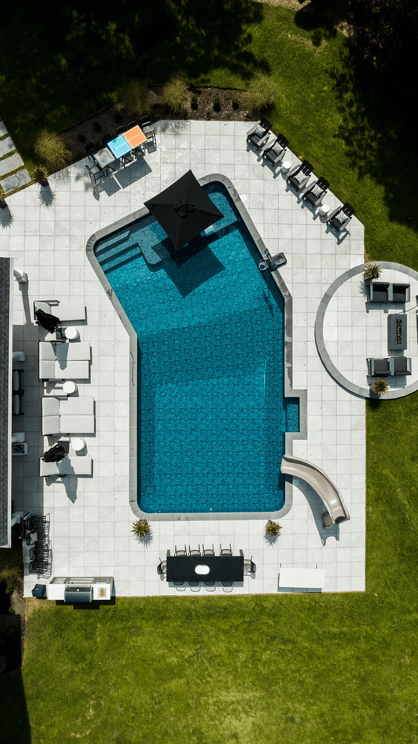 All the elements—even the slide—contribute to the harmony of this Budd Luxury Vinyl pool design.